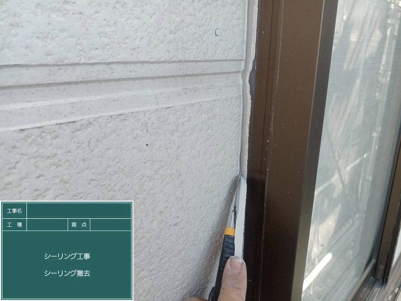 サッシ周りの古いシーリングをカッターで削り取る